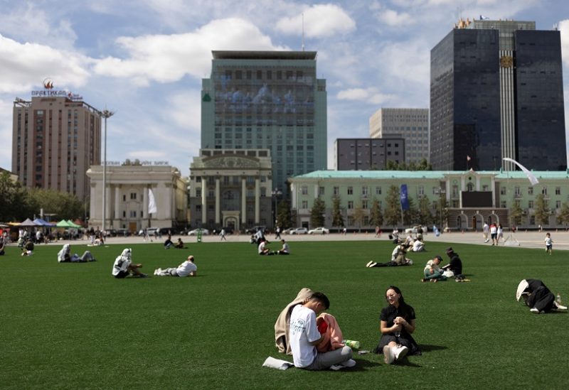 People rest while sitting on the artificial grass at Sukhbaatar Square, one day ahead of the arrival of Pope Francis, in Ulaanbaatar, Mongolia August 31, 2023. REUTERS/Carlos Garcia Rawlins