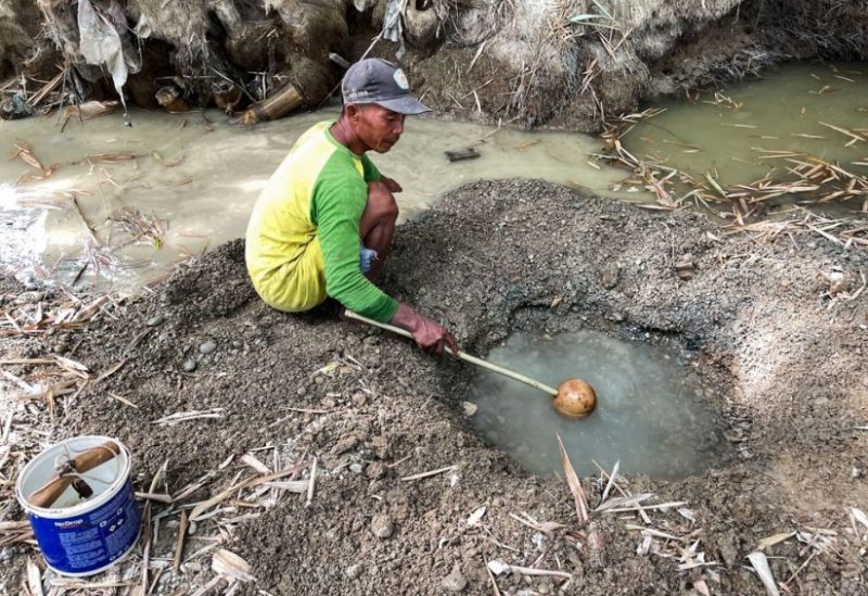 Sunardi, a 52-year-old tobacco farmer, collects murky water for daily needs from a hand-dug well on a dry riverbed, the only remainder of what was once a flowing river as drought strikes in Grobogan regency, Central Java province, Indonesia