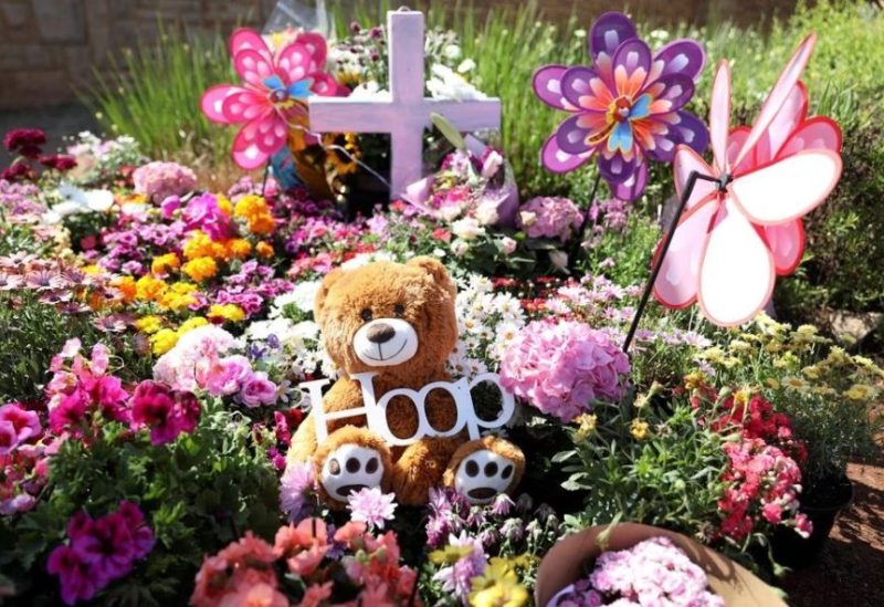 A teddy bear is seen among flowers placed outside where Lauren Anne Dickason, a woman charged with murdering her three young daughters just weeks after arriving in New Zealand from South Africa, used to live, in Pretoria, South Africa, September 24, 2021. REUTERS/Siphiwe Sibeko/File Photo