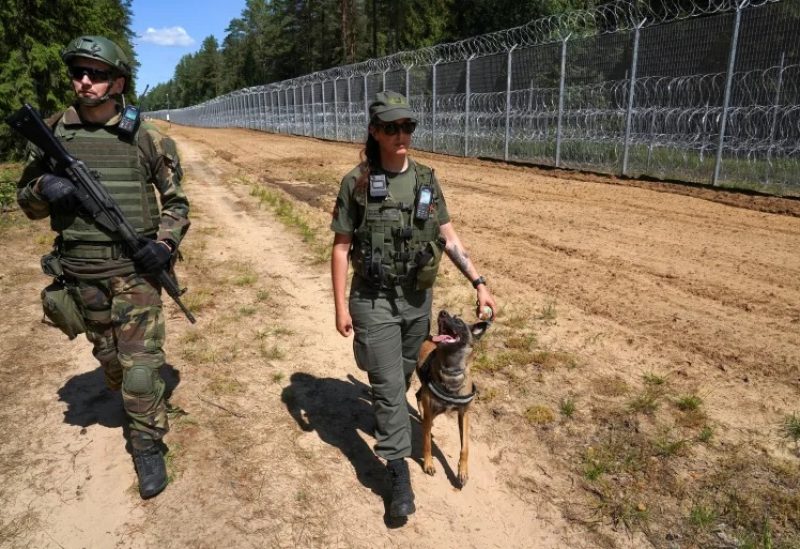 A member of Lithuanian Riflemen's Union and a Border Guard officer patrol along Belarus border in Kaniukai, Lithuania, in July 2023 [File: Janis Laizans/Reuters]