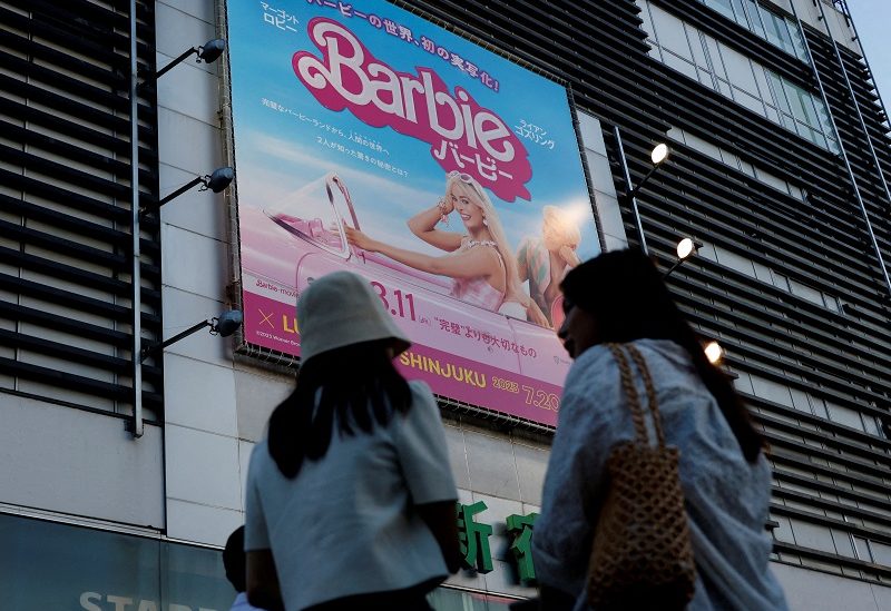 FILE PHOTO: Women stand in front of a promotional poster of film "Barbie" in Tokyo, Japan, August 3, 2023. REUTERS/Kim Kyung-Hoon//File Photo