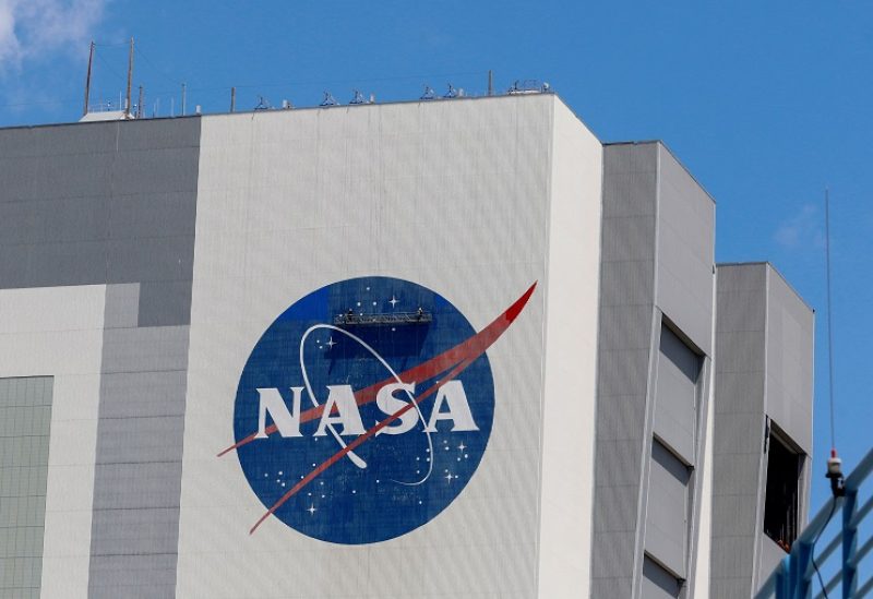 Workers pressure wash the logo of NASA on the Vehicle Assembly Building at the Kennedy Space Center in Cape Canaveral, Florida, U.S., May 19, 2020. REUTERS/Joe Skipper/File Photo