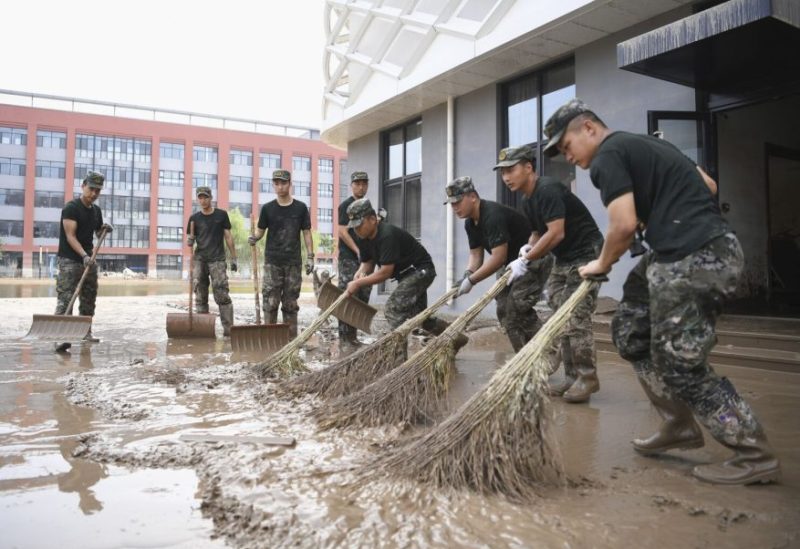 In this photo released by Xinhua News Agency, members of the armed police force clean up sludge left after the flood caused by rainstorms brought by Typhoon Doksuri at a high school in Zhuozhou, north China’s Hebei Province, Aug. 10, 2023. Severe floods in China’s northern province of Hebei brought by remnants of Typhoon Doksuri this month killed at least two dozens people and caused billions of dollars in economic losses, its provincial government said Friday, Aug. 11, 2023. (Zhu Xudong/Xinhua via AP) (Zhu Xudong / Associated Press)