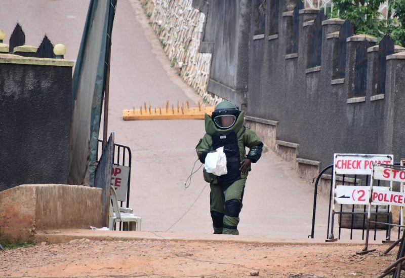 A bomb disposal expert dressed in his protective suit carries samples after a controlled detonation of an explosive device outside a Pentecostal church, Lubaga Miracle Centre, in the Lubaga suburb of south Kampala, Uganda September 3, 2023. REUTERS/Abubaker Lubowa