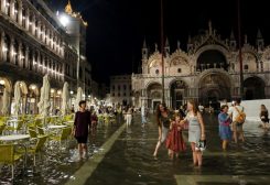 Tourists walk through flooded St Mark's Square after unusually high water levels in Venice, Italy, August 1, 2023. REUTERS/Manuel Silvestri/File Photo