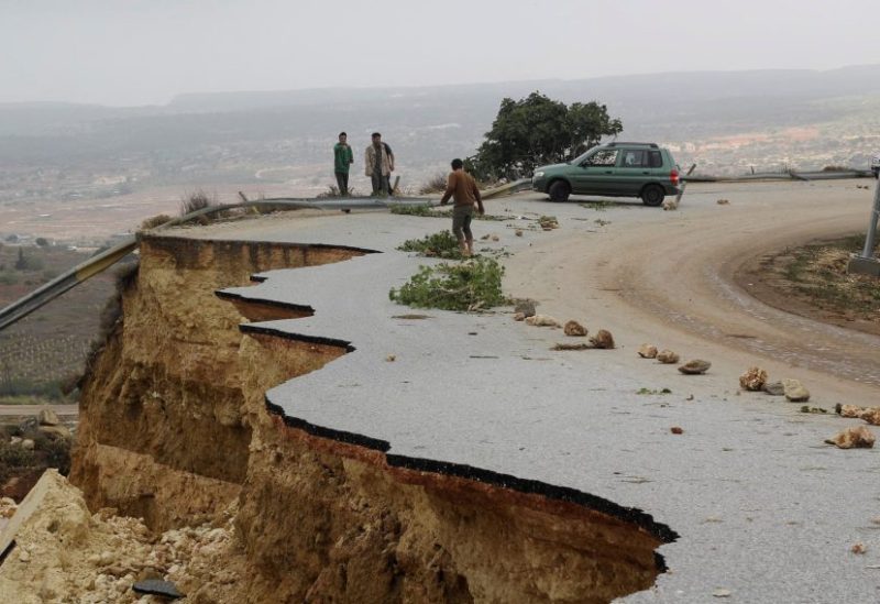 People stand in a damaged road as a powerful storm and heavy rainfall flooded hit Shahhat city, Libya, September 11, 2023. REUTERS/Omar Jarhman
