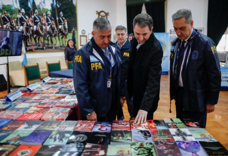 Victor Garelik, DAIA's executive director (Delegation of Argentine-Israeli Associations), stands with Argentine federal police deputy chief commissioner Osvaldo Mato, as they look to Nazi propaganda books, after a raid carried out by Argentina's Anti-Terrorist Investigation Unit Department, where they arrested a man leading a propaganda distribution operation, in Buenos Aires, Argentina September 13, 2023. REUTERS/Agustin Marcarian