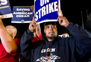 United Auto Workers hold up strike signs as their fellow union members walk out of the job at the Ford Michigan Assembly Plant in Wayne, Michigan, U.S., September 15, 2023. REUTERS/Eric Cox