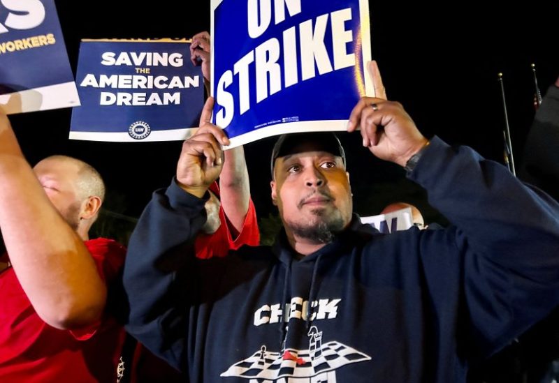 United Auto Workers hold up strike signs as their fellow union members walk out of the job at the Ford Michigan Assembly Plant in Wayne, Michigan, U.S., September 15, 2023. REUTERS/Eric Cox