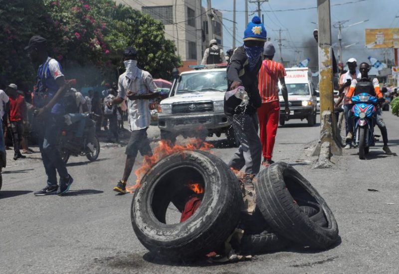 A demonstrator pours liquid fuel onto tires to burn them at a barricade during a protest against insecurity and demand the resignation of Haiti's Prime Minister Ariel Henry, in Port-au-Prince, Haiti September 17, 2023. REUTERS/Ralph Tedy Erol