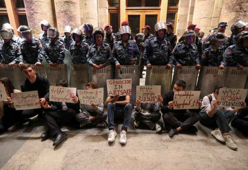Protesters sit in front of law enforcement officers near the government building during a rally to support ethnic Armenians in Nagorno-Karabakh following Azerbaijani armed forces' offensive operation executed in the region, in Yerevan, Armenia, September 20, 2023. REUTERS/Irakli Gedenidze
