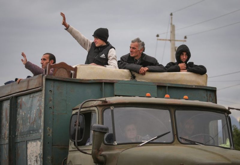 Refugees from Nagorno-Karabakh region ride in the back of a truck as they arrive in the border village of Kornidzor, Armenia, September 26, 2023. REUTERS/Irakli Gedenidze