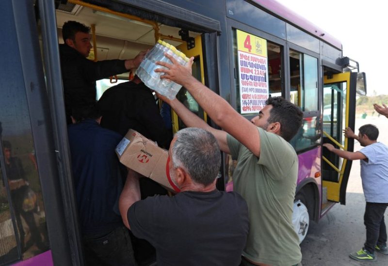 Volunteers give water and food to refugees from Nagorno-Karabakh region arriving in the border village of Kornidzor, Armenia, September 29, 2023. REUTERS/Irakli Gedenidze
