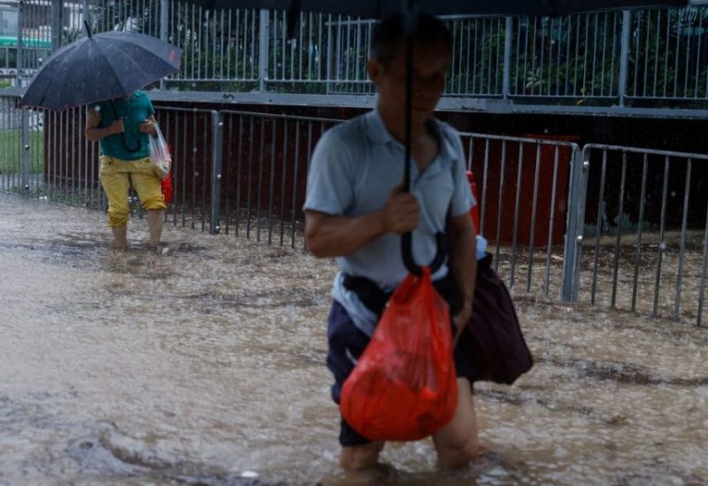 People make their way through a flooded area after heavy rains, in Hong Kong, China, September 8. REUTERS
