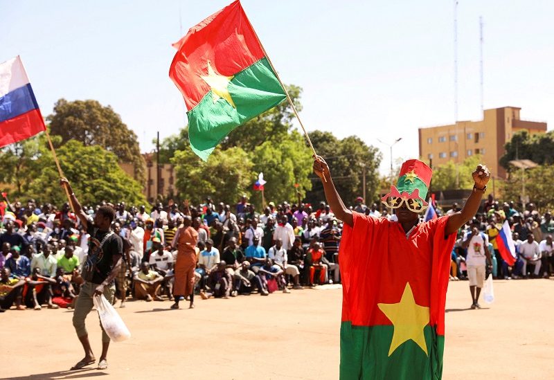 FILE PHOTO: A man holds his national flag as people gather to show their support to the Junta leader Ibrahim Traore and demand the departure of the French ambassador at the Place de la Nation in Ouagadougou, Burkina Faso January 20, 2023. REUTERS/Vincent Bado/File Photo