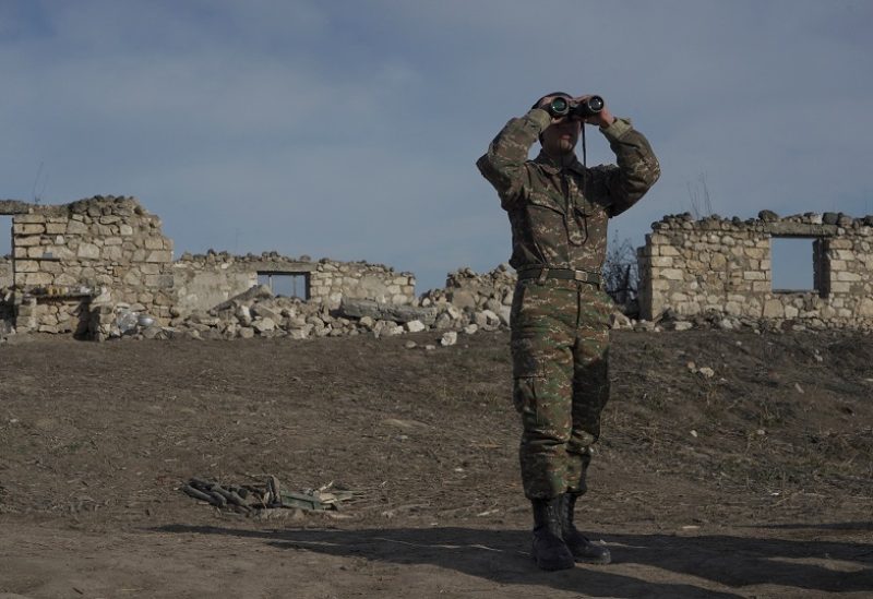 FILE PHOTO: An ethnic Armenian soldier looks through binoculars as he stands at fighting positions near the village of Taghavard in the region of Nagorno-Karabakh, January 11, 2021. Picture taken January 11, 2021. REUTERS/Artem Mikryukov/File Photo