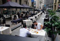 People eat at a mostly empty restaurant with tables on the street, in the financial district during the coronavirus disease (COVID-19) pandemic in the Manhattan borough of New York City, New York, U.S., September 9, 2020