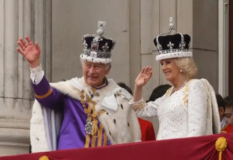 Britain’s King Charles III wearing the Imperial state Crown, and Britain’s Queen Camilla wearing a modified version of Queen Mary’s Crown wave from the Buckingham Palace balcony after viewing the Royal Air Force fly-past in central London on May 6, 2023, after their coronations. (Reuters)