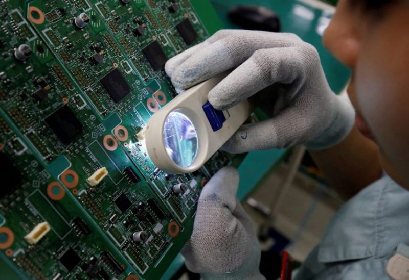 A woman looks through a magnifying glass to check errors of a printer circuit board at Manutronics Factory in Bac Ninh province, Vietnam May 30, 2018. REUTERS