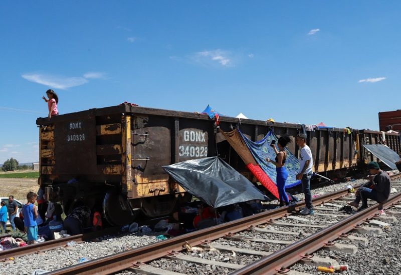 Migrants stranded while traveling by train towards the U.S. border are seen next to railroad cars, amid the ongoing suspension of dozens of northbound trains over fears around migrant safety, in the community of Miguel Hidalgo de Ojuelos, on the outskirts of Fresnillo, in Zacatecas state, Mexico September 29, 2023. REUTERS/Edgar Chavez