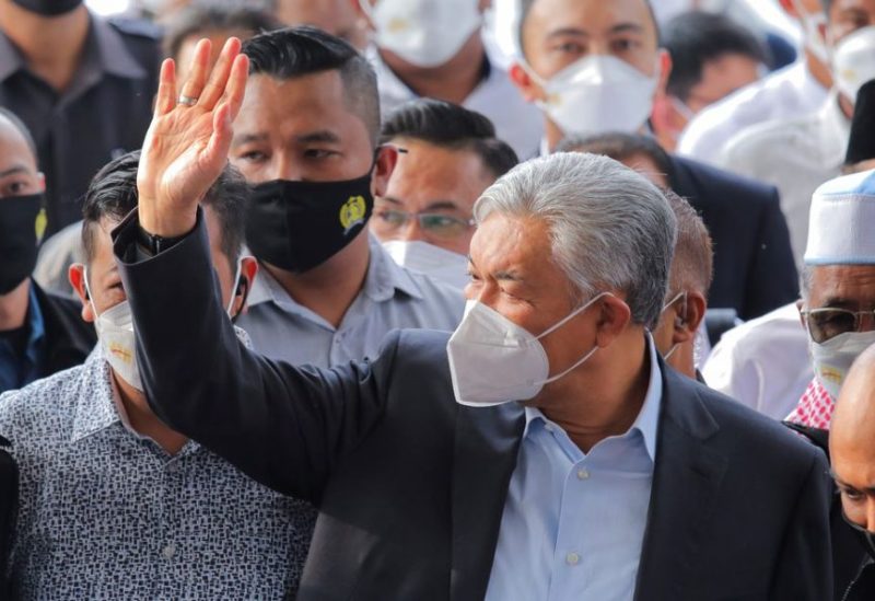 Former Malaysian deputy prime minister and current president of the ruling party UMNO Ahmad Zahid Hamidi waves to his supporters as he arrives at the Kuala Lumpur High Court complex for the court's decision on whether he will have to enter his defence or be acquitted of corruption and money laundering charges in Kuala Lumpur, Malaysia