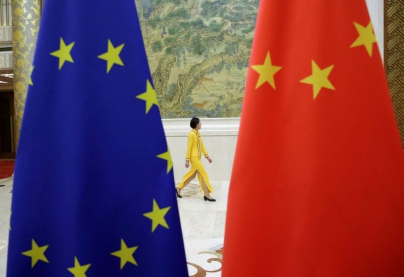 An attendant walks past EU and China flags ahead of the EU-China High-level Economic Dialogue at Diaoyutai State Guesthouse in Beijing, China June 25, 2018. REUTERS