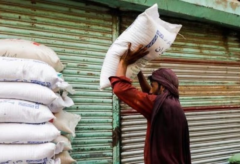A labourer stacks sacks of sugar outside a shop at a wholesale market in Karachi, Pakistan June 9, 2023. REUTERS/Akhtar Soomro/File photo