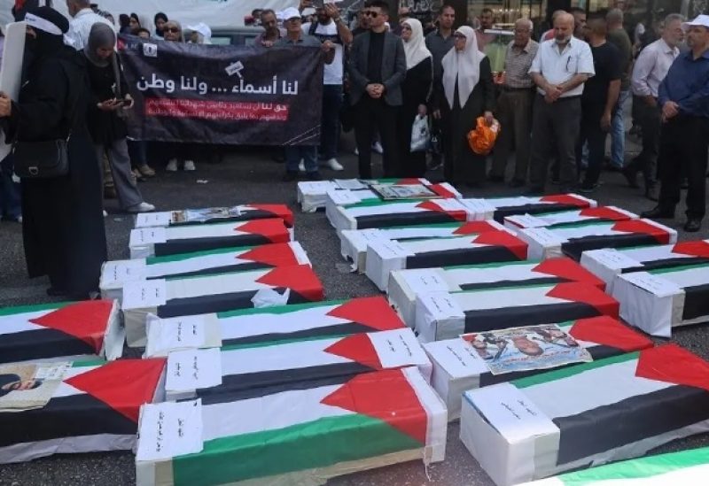 Protesters stand by mock coffins covered with the Palestinian flag as they demand the return of the bodies of their slain relatives held by Israeli forces, during a rally in Nablus city in the occupied West Bank on August 27, 2023. (AFP)