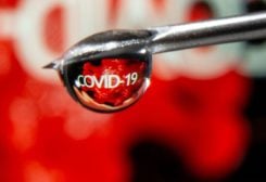The word "COVID-19" is reflected in a drop on a syringe needle in this illustration taken November 9, 2020. REUTERS/Dado Ruvic/Illustration/File Photo
