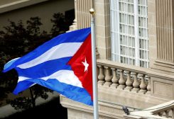 The Cuban flag flutters in the wind after being raised at the Cuban Embassy reopening ceremony in Washington July 20, 2015. REUTERS/Gary Cameron/File Photo