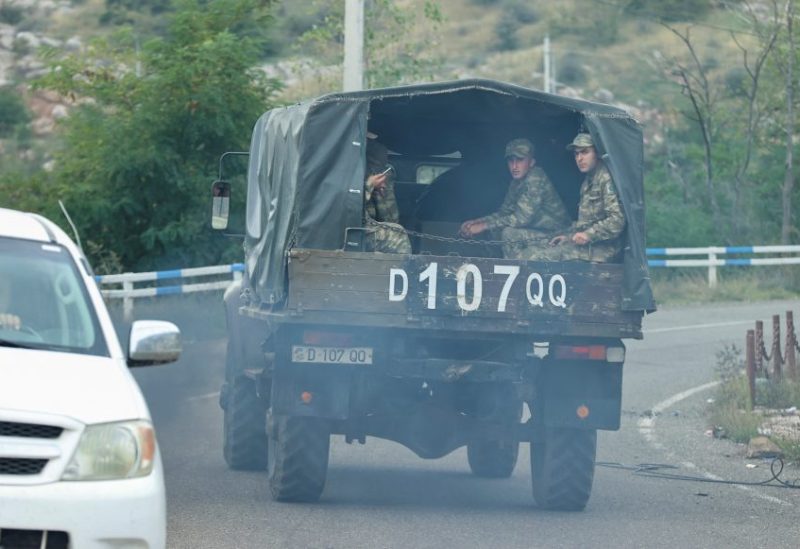 A view through a car window shows Azerbaijani service members riding in the back of a truck in Stepanakert city, known as Khankendi by Azerbaijan, following an Azeri military operation and a further mass exodus of ethnic Armenians from the region of Nagorno-Karabakh, October 2, 2023. REUTERS/Aziz Karimov/File Photo