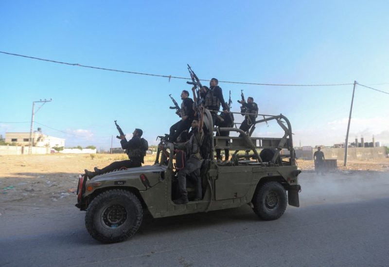 Palestinian militants ride an Israeli military vehicle that was seized by gunmen who infiltrated areas of southern Israel, in the northern Gaza Strip October 7, 2023. REUTERS/Ahmed Zakot