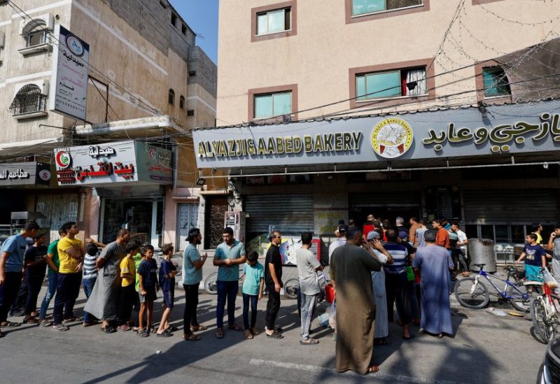 Palestinians wait to buy bread outside a bakery, amid the ongoing conflict between Israel and Palestinian Islamist group Hamas, in Khan Younis in the southern Gaza Strip, October 14, 2023. REUTERS/Mohammed Salem/File Photo