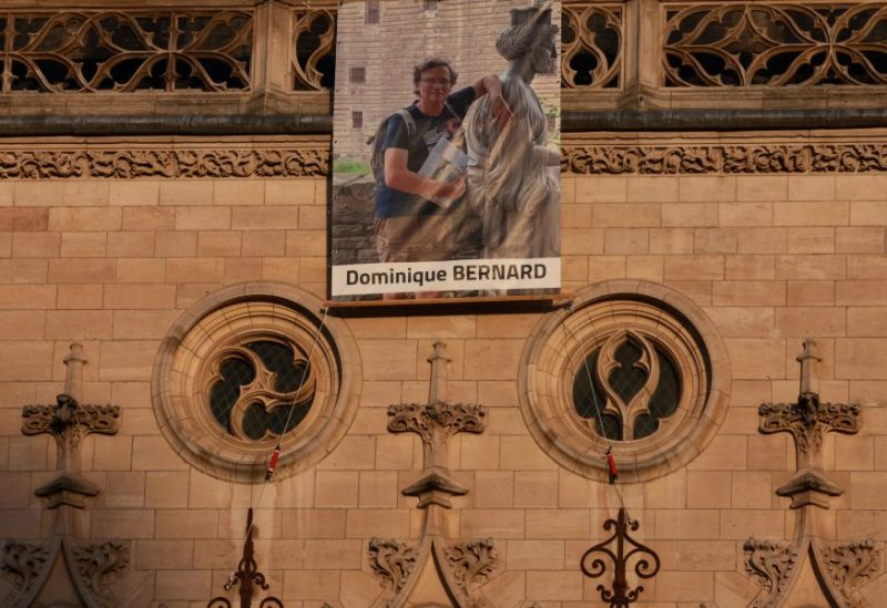 A portrait of French teacher Dominique Bernard, who was killed in a knife attack in a high school, hangs on the beffroi (belfry) of Arras city hall before the funeral ceremony at the Notre-Dame-et-Saint-Vaast Cathedral in Arras, northern France, October 19, 2023. REUTERS/Pascal Rossignol