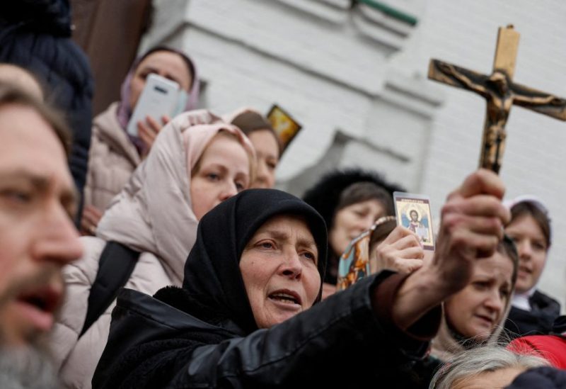 Believers of the Ukrainian Orthodox Church, accused of being linked to Moscow, pray while they block an entrance to a church at a compound of the Kyiv Pechersk Lavra monastery, amid Russia's attack on Ukraine, in Kyiv, Ukraine March 31, 2023. REUTERS/Valentyn Ogirenko/File Photo