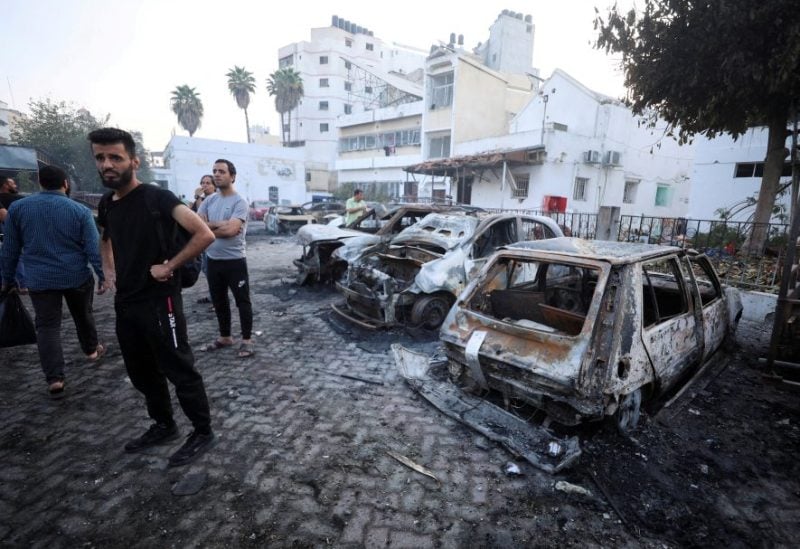 People inspect the area of Al-Ahli hospital where hundreds of Palestinians were killed in a blast that Israeli and Palestinian officials blamed on each other, and where Palestinians who fled their homes were sheltering amid the ongoing conflict with Israel, in Gaza City, October 18, 2023. REUTERS/Mohammed Al-Masri/File Photo