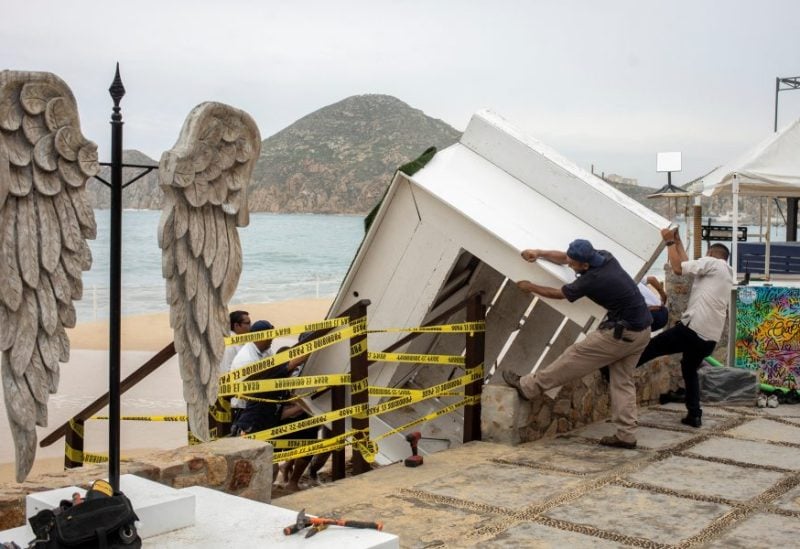 Workers remove a stand off a beach as Hurricane Norma barrels towards the Baja California peninsula, in Cabo San Lucas, Mexico, October 20, 2023. REUTERS/Fernando Castillo