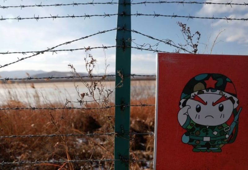 A cartoon soldier is depicted on part of a warning sign on barbed wire on the Chinese side of the border between Russia, China and North Korea near the town of Hunchun, China, November 24, 2017. REUTERS/Damir Sagolj/File Photo