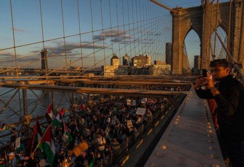 People cross the Brooklyn Bridge as they take part in a protest in support of the Palestinian people in New York on October 28, 2023.