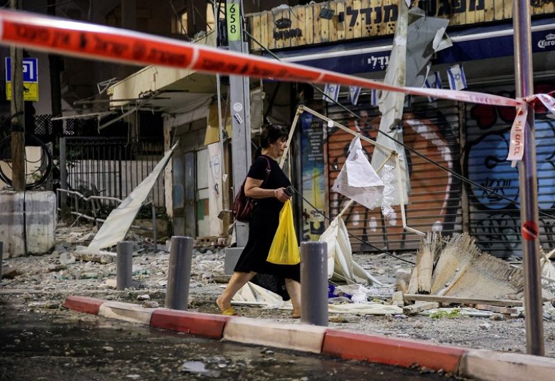 A woman walks past the site where a rocket launched from the Gaza Strip landed in Tel Aviv, Israel October 7, 2023. REUTERS/Itai Ron ISRAEL OUT. NO COMMERCIAL OR EDITORIAL SALES IN ISRAEL