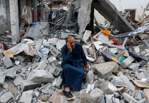 A Palestinian sits on the rubble of a building destroyed in Israeli strikes, in Rafah in the southern Gaza Strip October 9, 2023. REUTERS/Ibraheem Abu Mustafa TPX IMAGES OF THE DAY