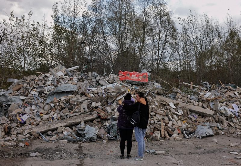 Two women react in front of a pile of rubble that is left of the cafe that hosted the wake and was hit by a Russian missile, following a Russian military strike, amid Russia's attack on Ukraine, in the village of Hroza, Kharkiv region, Ukraine October 6, 2023. REUTERS/Thomas Peter