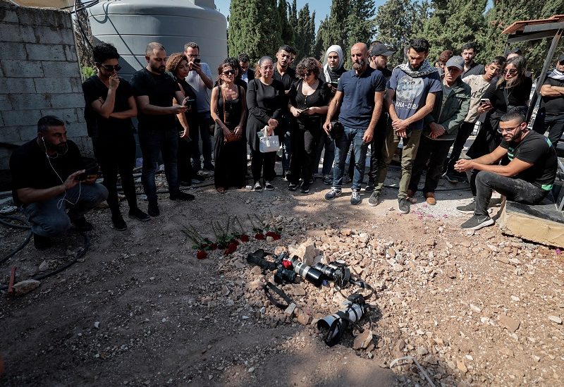Journalists put their cameras on the grave of Issam Abdallah, a Lebanese national and Reuters videojournalist who was killed in southern Lebanon by shelling from the direction of Israel, to pay tribute to him during his funeral in his home town of Al Khiyam, Lebanon October 14, 2023. REUTERS/Zohra Bensemra