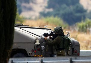 An Israeli soldier looks through the site of his gun, as tension mounts between the Lebanon and Israel, in northern Israel, October 10, 2023. REUTERS