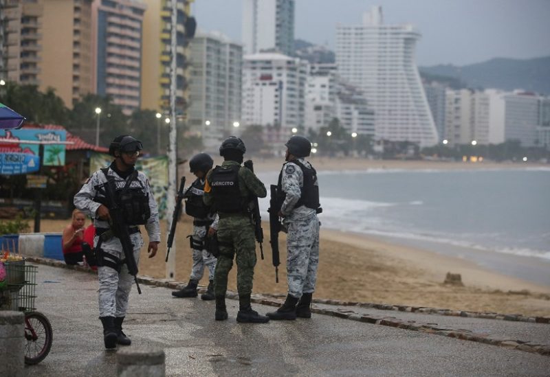 Members of the federal forces chat as they keep watch at a beach as Hurricane Otis barrels towards Acapulco, Mexico, October 24, 2023. REUTERS/Javier Verdin