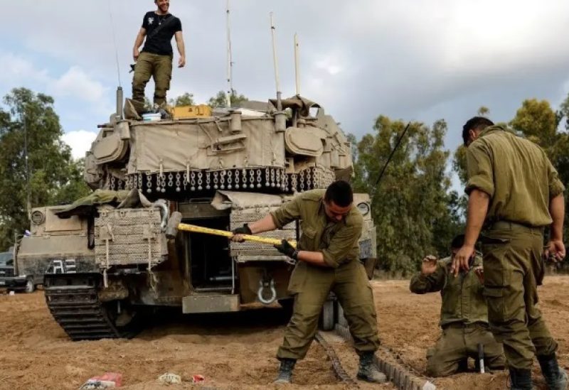 Israeli soldiers carry out maintenance on an Israeli tank near Israel’s border with the Gaza Strip, in southern Israel October 15, 2023.