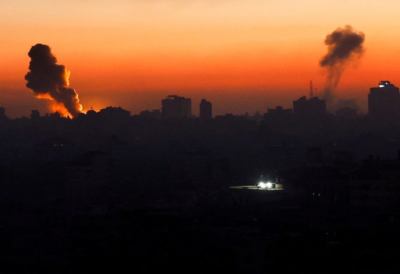 Smoke billows following Israeli strikes amid the ongoing conflict between Israel and the Palestinian Islamist group Hamas, as a building stands illuminated in a darkened neighbourhood in Gaza, October 13, 2023. REUTERS/Mohammed Salem TPX IMAGES OF THE DAY