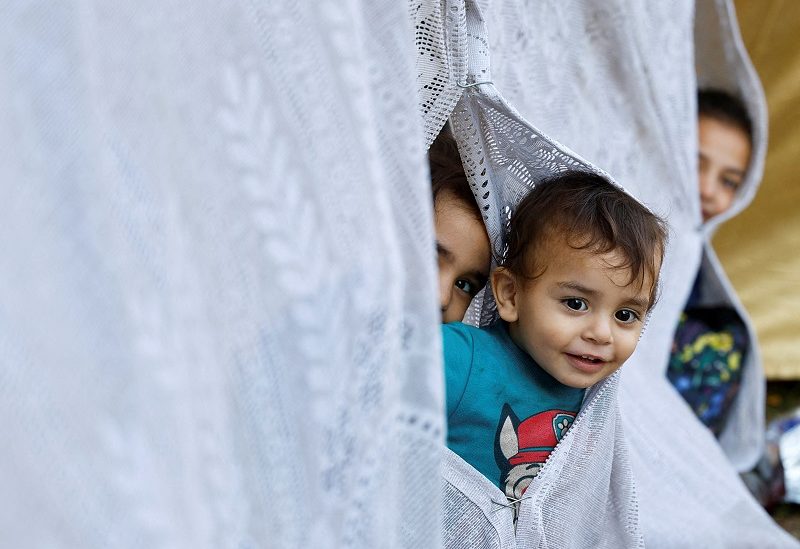 Palestinian children who fled their homes due to Israeli strikes look through a makeshift tent as they shelter at al-Shifa hospital in Gaza City, October 12, 2023. REUTERS/Mohammed Salem TPX IMAGES OF THE DAY