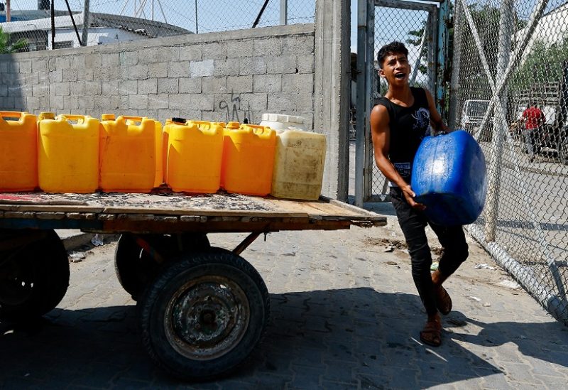 A man holds a container as Palestinians gather to fill water from public taps amid the conflict with Israel in Khan Younis, in the southern Gaza Strip, October 11, 2023. REUTERS/Ibraheem Abu Mustafa