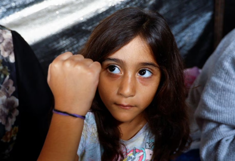 Daughter of Palestinian man Ali Daba, who decided with his wife to split their children up and mark them with bracelets to help identify them, in fear of them being killed in Israeli strikes, shows her bracelet at their shelter in Khan Younis in the southern Gaza Strip October 24, 2023